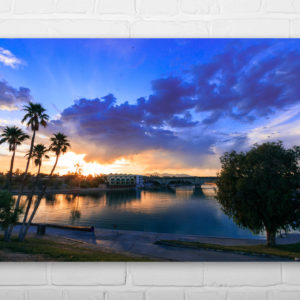 Sunset over Lake Havasu City, Arizona with the London Bridge in the background. Reflections, clouds, and palm trees.